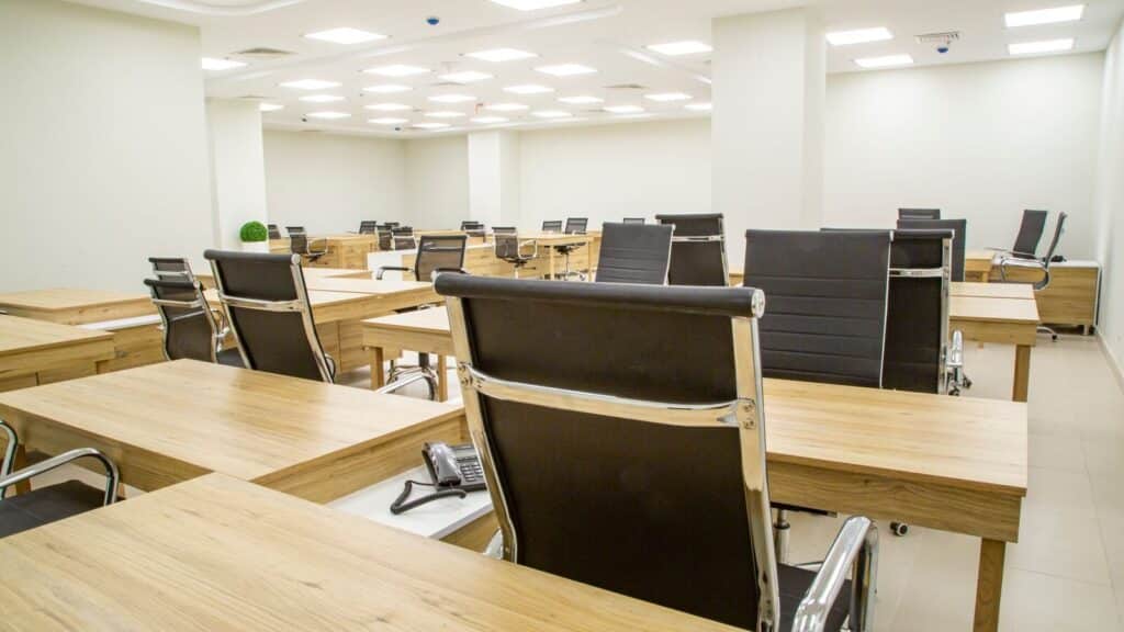 Bureau moderne et lumineux avec tables en bois et fauteuils vides, symbole de la création d'un bureau d'études